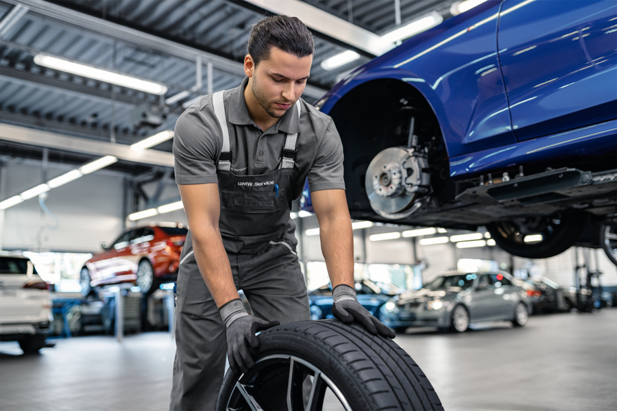 Servicetechniker montiert ein Original BMW Winterkomplettrad in der Werkstatt der Wahl-Group